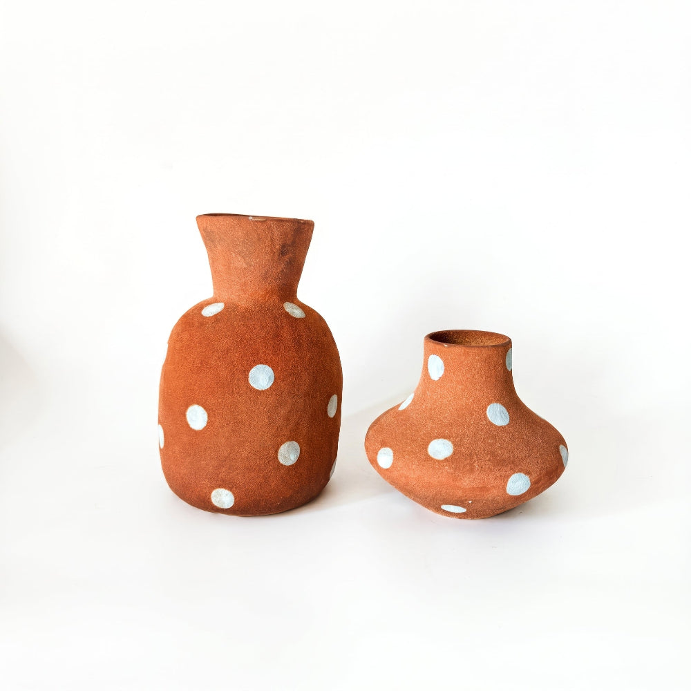 wo handmade terracotta ceramic vases featuring hand-painted white polka dots, displayed against a white background.