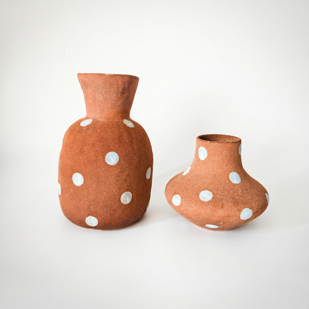 wo handmade terracotta ceramic vases featuring hand-painted white polka dots, displayed against a white background.