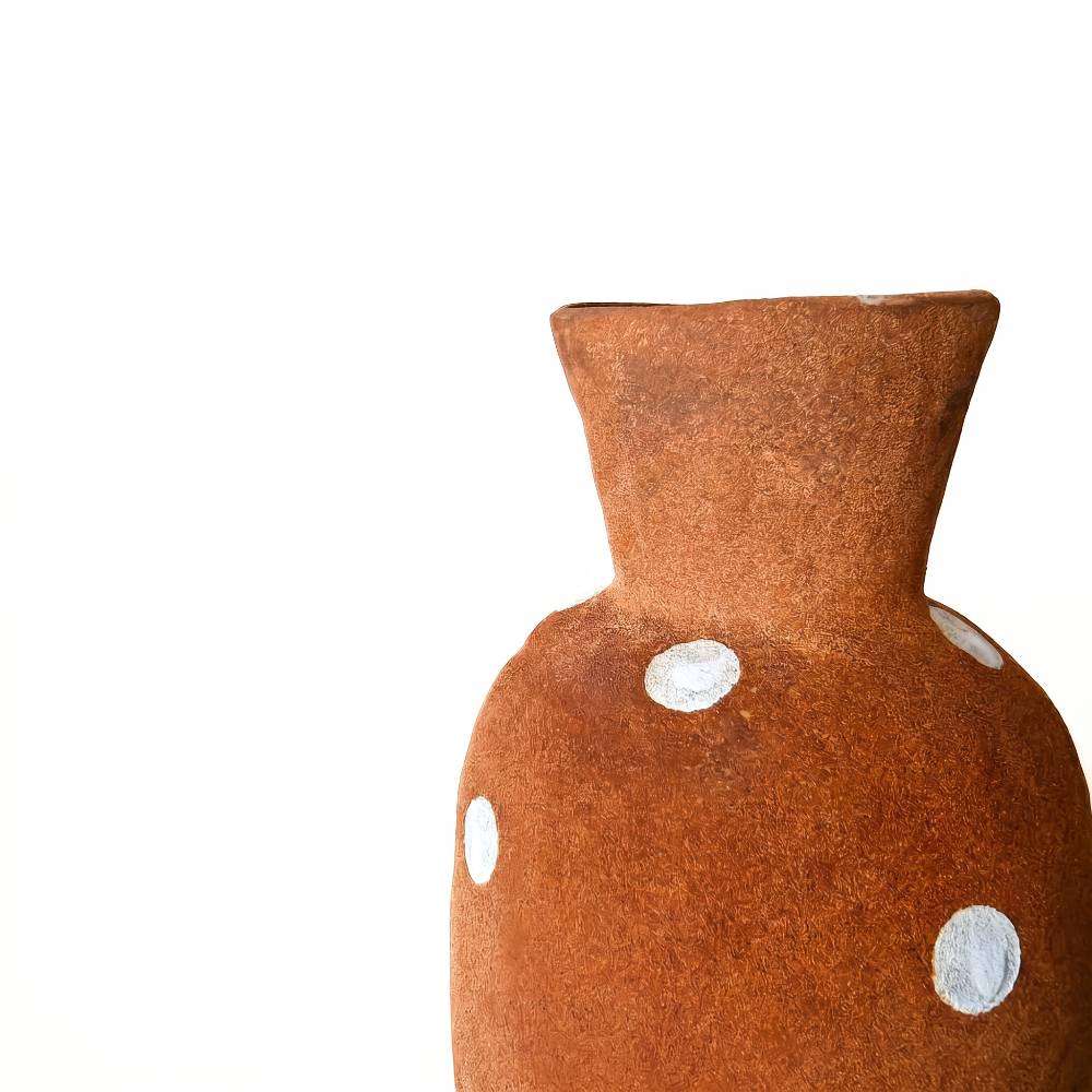 Close-up detail of a rustic terracotta vase by Kove Ceramics, highlighting the coarse earthy clay texture and whimsical hand-painted white polka dots